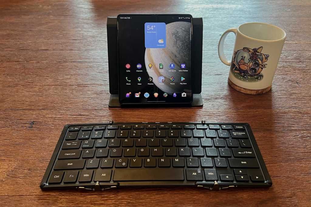 A foldable keyboard in front of a foldable phone, plus a Toejam & Earl mug